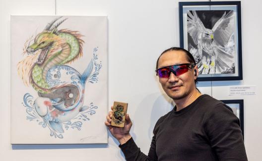 man standing next to dragon drawing