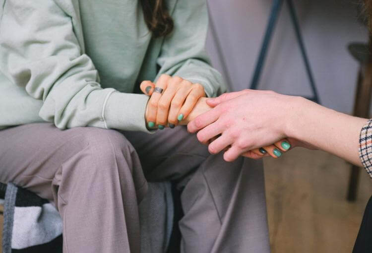 people consoling and holding hands
